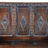 An antique Charles II period oak settle with a raised-paneled back. view 3
