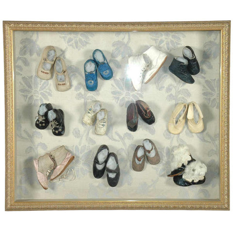 A collection of Victorian and Edwardian baby shoes, now mounted and framed. View 1
