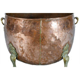 A Large Circular Copper Bin on Brass Paw Feet
