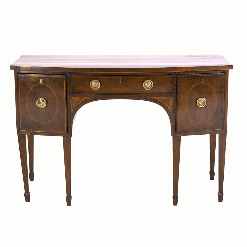 A mahogany bowfronted sideboard standing on tapered legs ending in spade feet. view 1