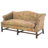 A 19th century George III period sofa of camelback form with rolled arms. view 1