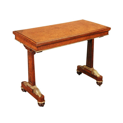 Amboyna card table with gilt accents and recessed castors. View 1