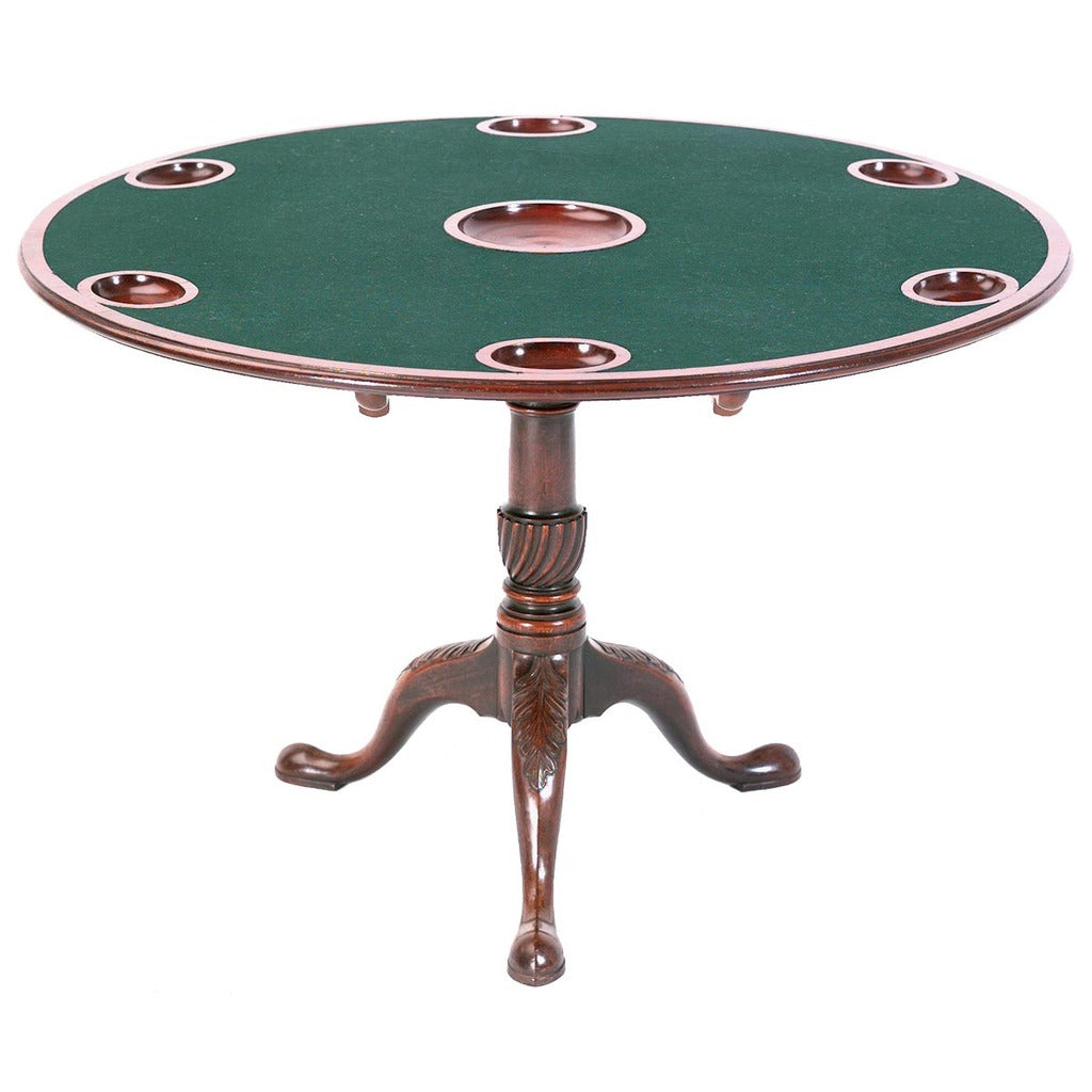 A mahogany games table with acanthus leaf-carved pedestal and money wells in the top. view 1