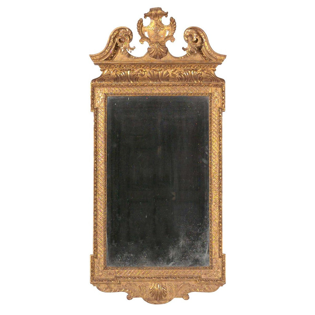A 18th century George III architectural gilt mirror with swan neck pediment and shield cartouche. view 1