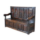 An antique Charles II period oak settle with a raised-paneled back. view 1